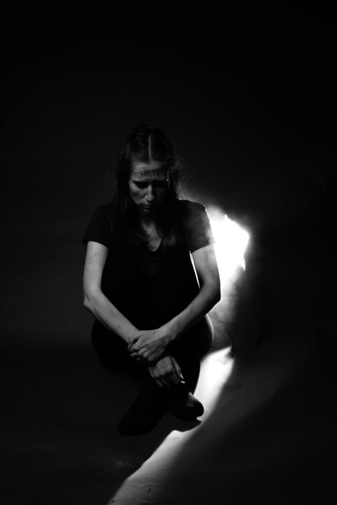 Moody black and white portrait of a young woman in deep thought.